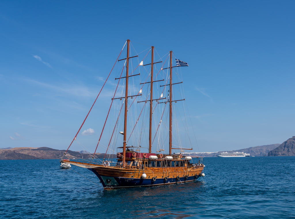 Traditional Greek sailboat will take you on your volcano tour Santorini is famous for.
